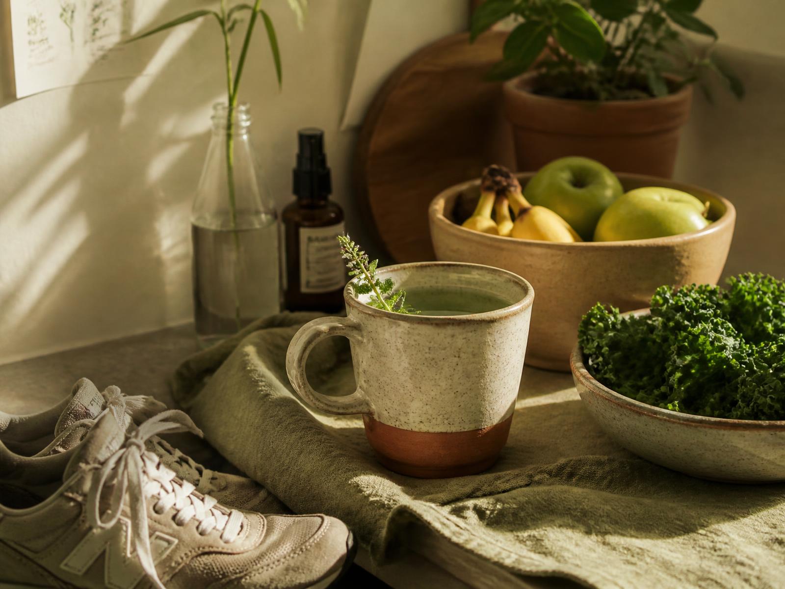 Sunlit kitchen with herbal tea, fresh produce, and walking shoes